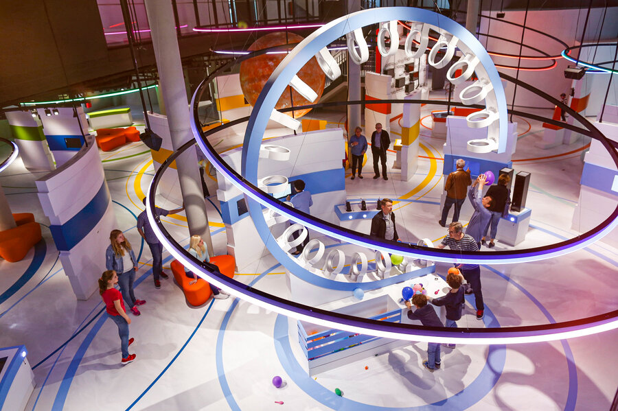 Blick in die Ausstellung - Besucher stehen um einen Looping  