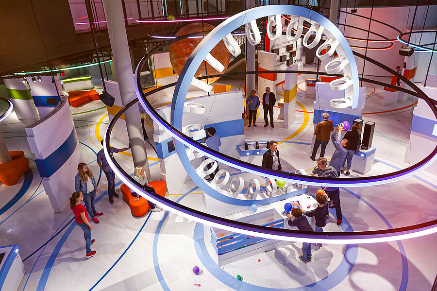 Blick in die Ausstellung - Besucher stehen um einen Looping  