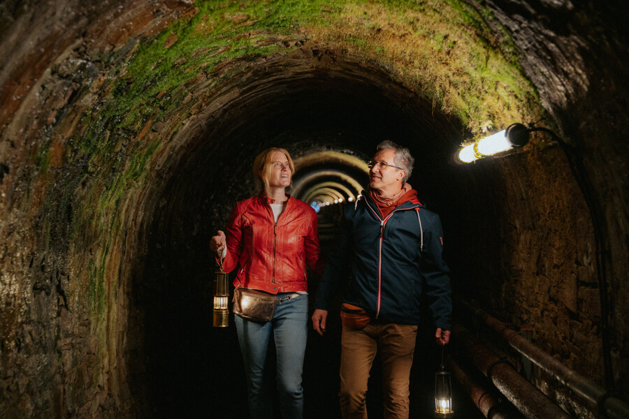 2 Personen mit GRubenlampen im Bergwerksstollen