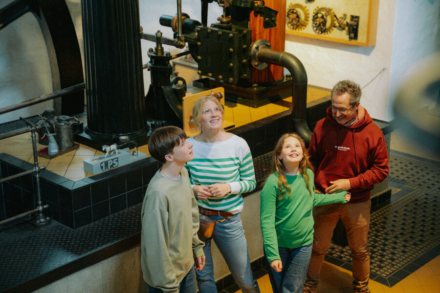 Eine Familie in der Ausstellung vor einer Dampfmaschine