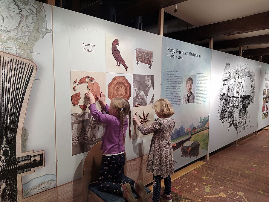 Kinder an der Intarsien-Mitmachwand im Museum am Marstall